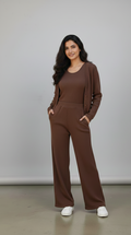 Woman wearing a brown outfit with a matching cardigan against a plain background