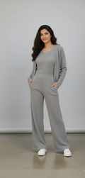 Woman wearing a gray outfit standing against a plain background