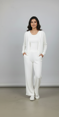 Woman wearing a white outfit against a plain background