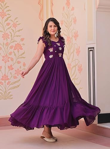 Woman wearing a purple dress with floral embroidery in a decorated room.