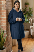 Woman wearing a navy blue hoodie holding a mug indoors.