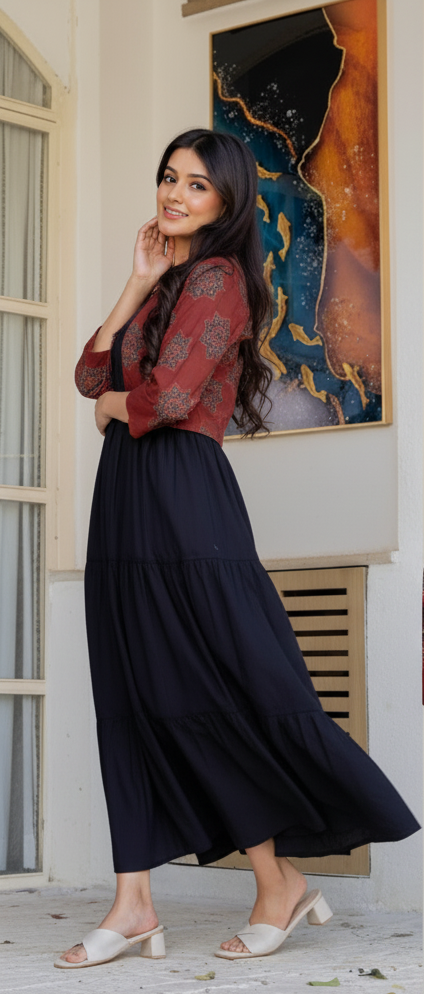Woman wearing a red patterned jacket over a black dress, standing indoors.
