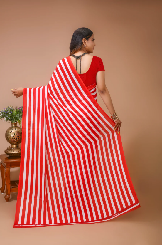 Woman wearing a red and white striped saree against a beige background