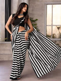 Woman wearing a black and white striped saree with a plain background
