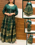Green and gold patterned dress with inset images on a wooden background