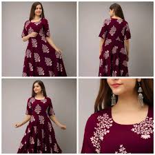 Woman wearing a maroon dress with white floral patterns on a gray background