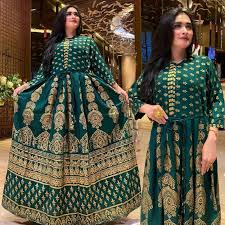 Green and gold patterned dress with inset images on a wooden background